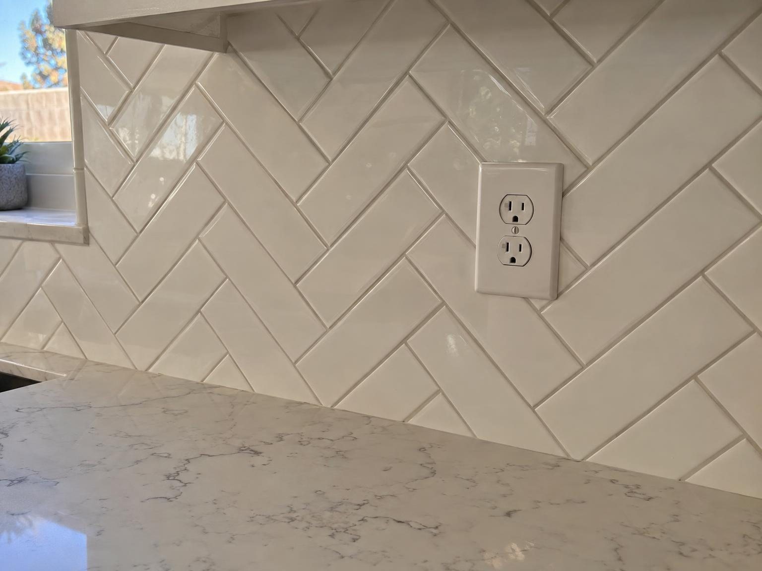 White herringbone backsplash over a marble-look counter