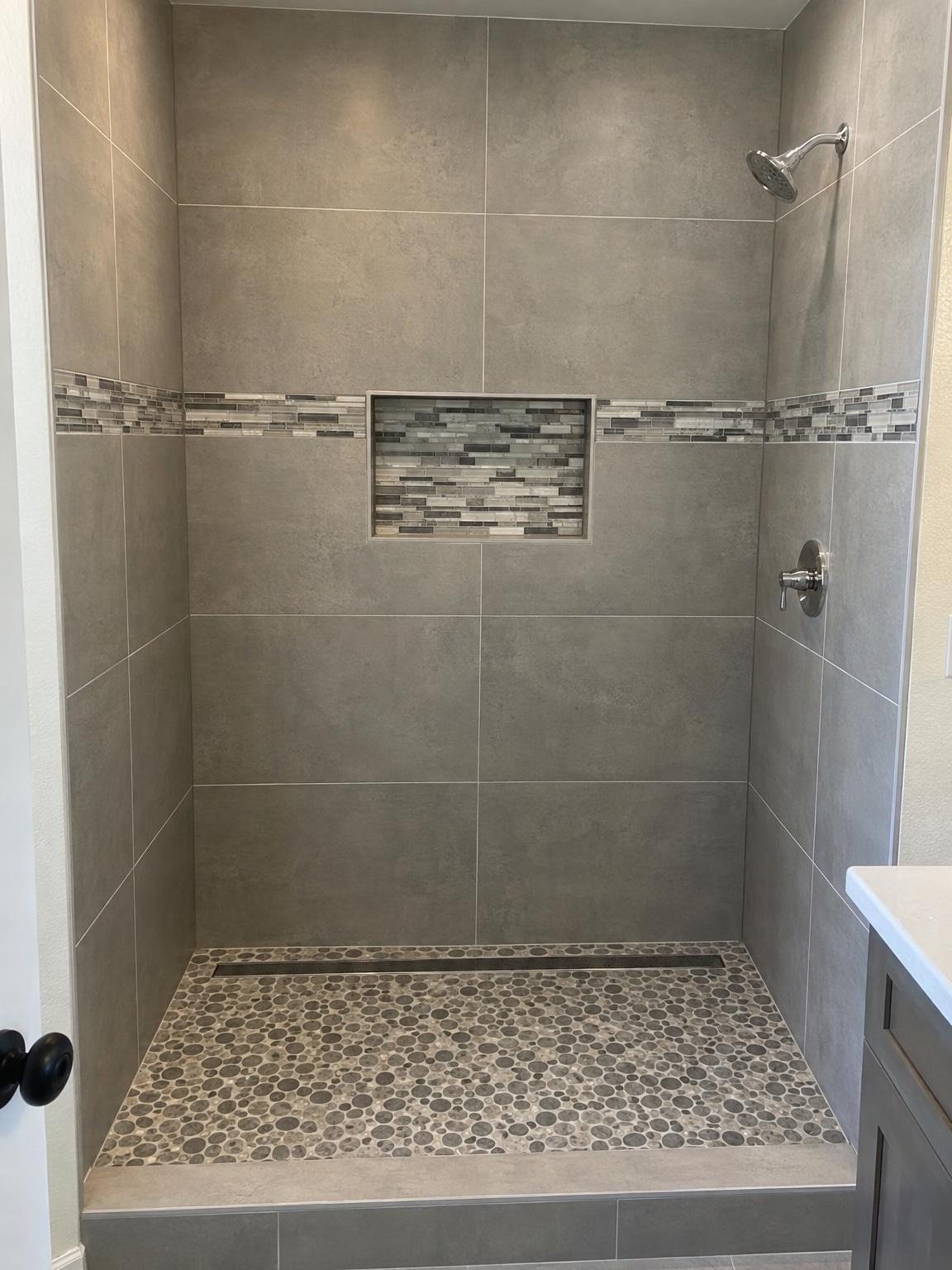 Tiled walk-in shower with a niche