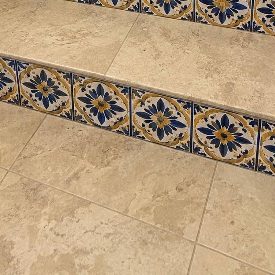 Close-up of patterned tile risers on travertine steps
