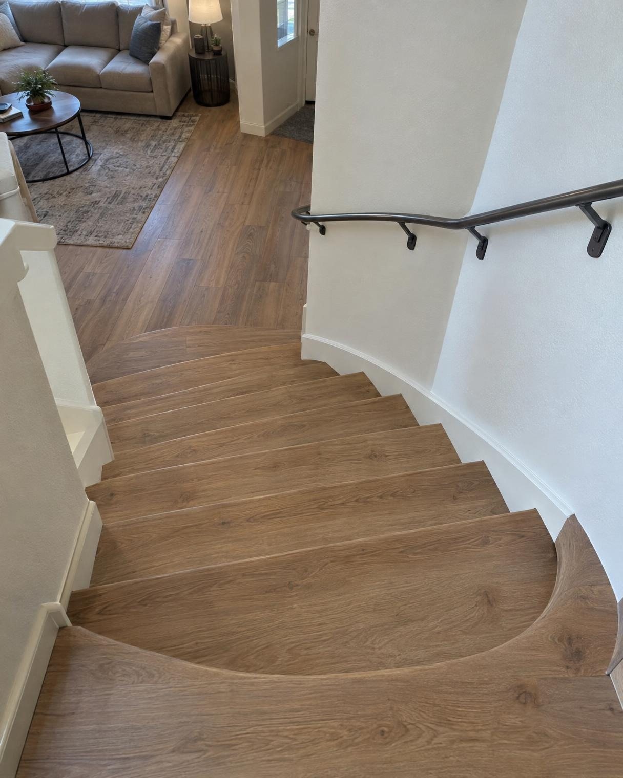 Curved bottom stairs clad in wood-look planks